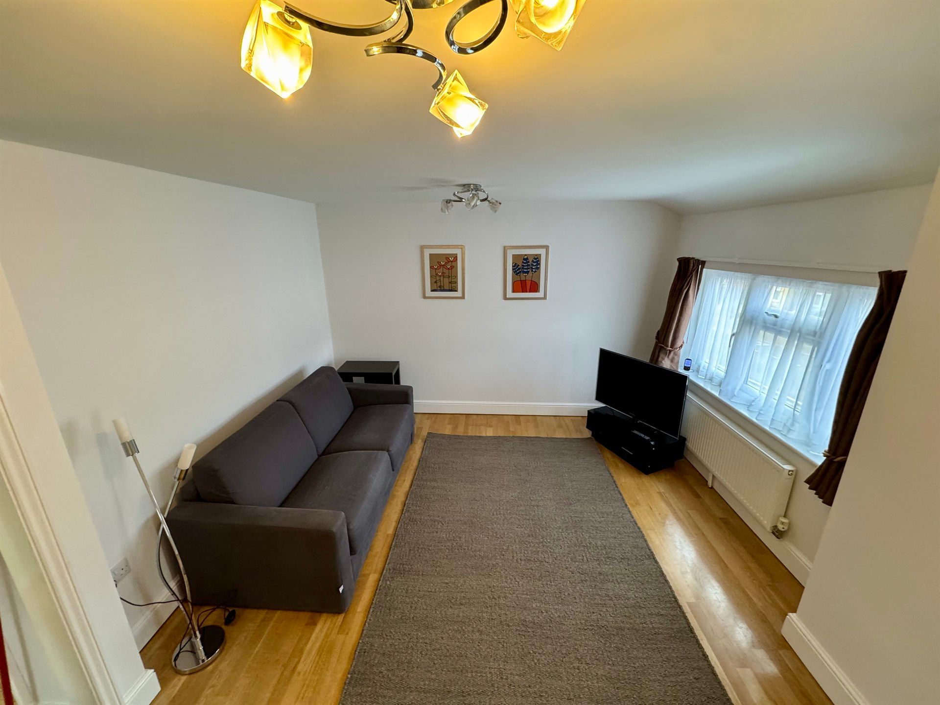 A living room with a couch , television , and rug.