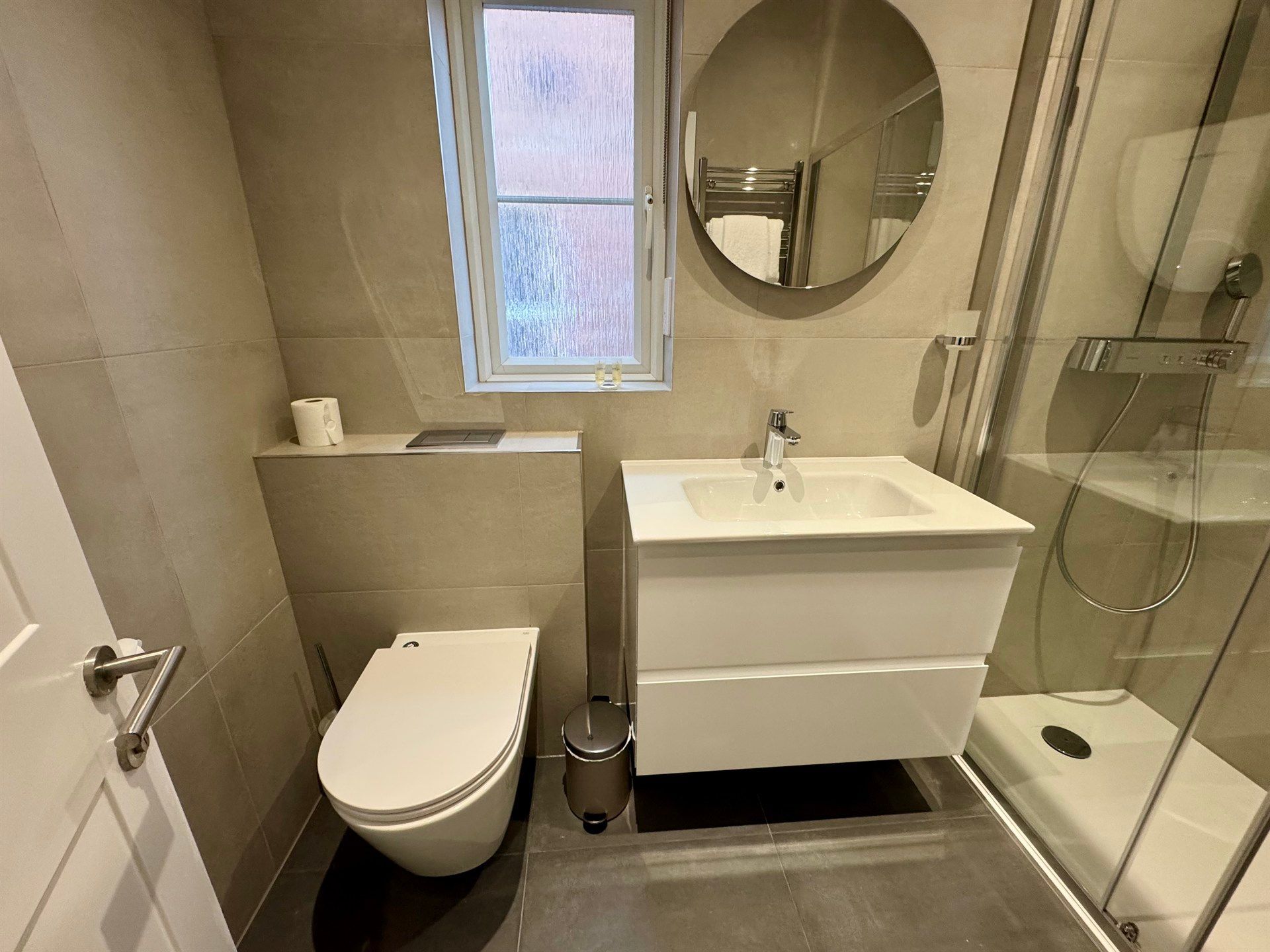 A bathroom with a toilet , sink , and shower.