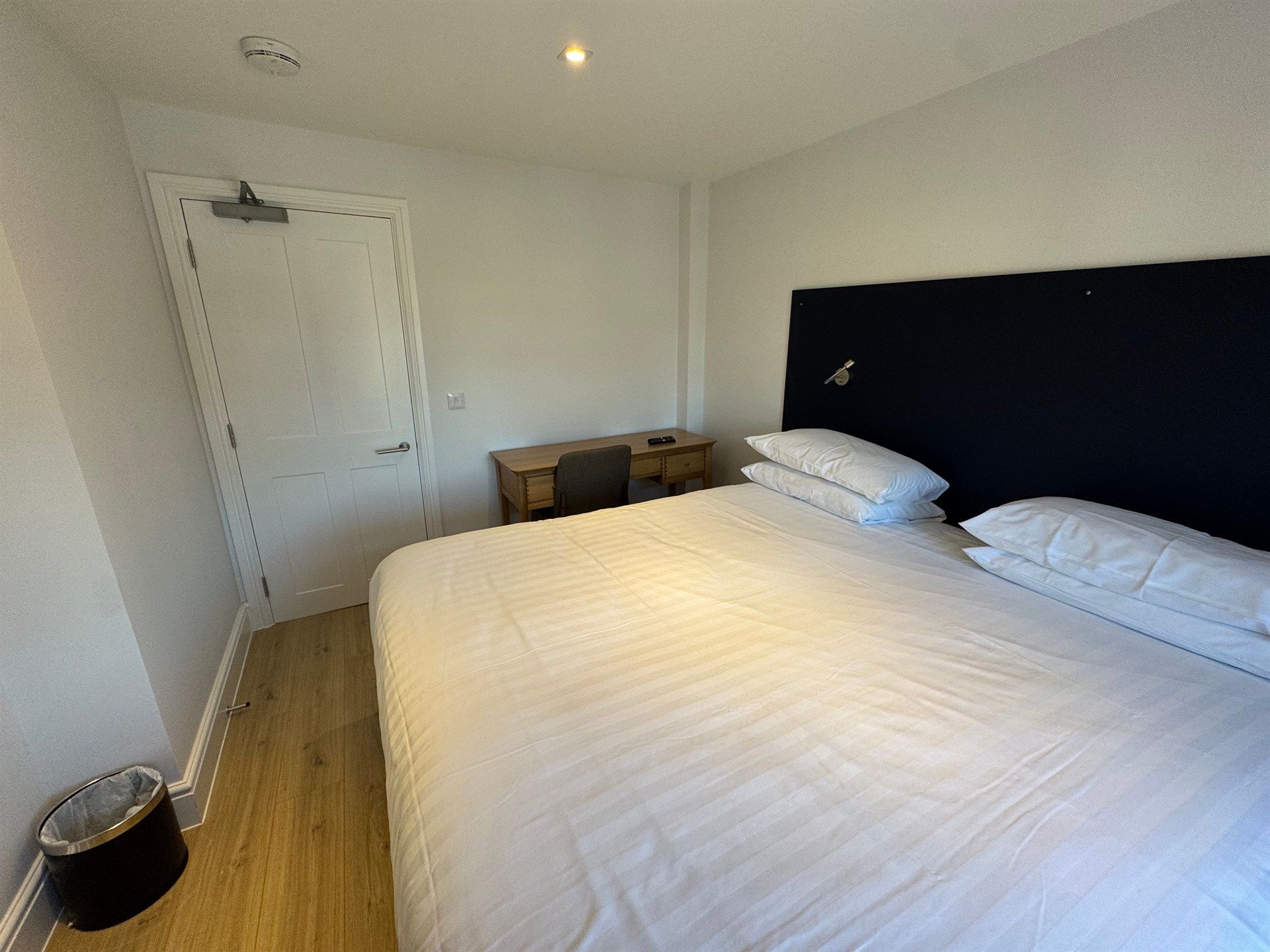 A bedroom with a king size bed and a desk.