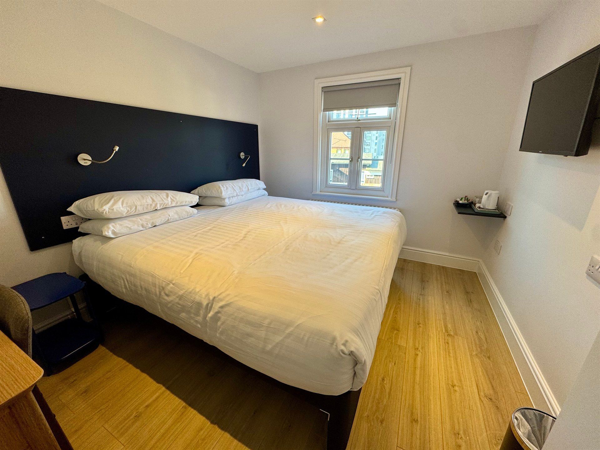 A hotel room with a large bed and a window.