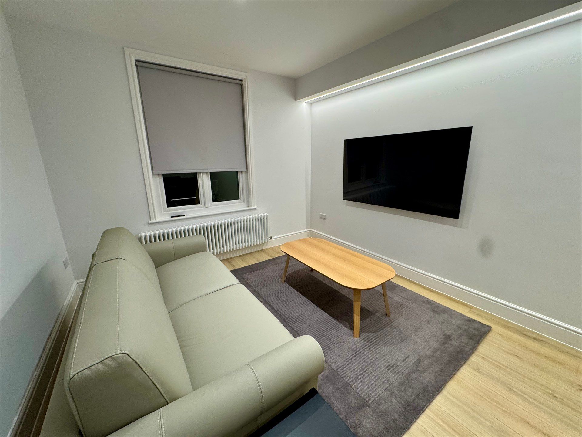 A living room with a couch , coffee table , and television.