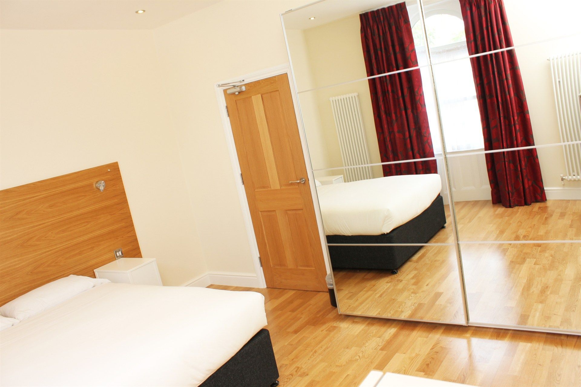 A bedroom with a bed and a large mirror