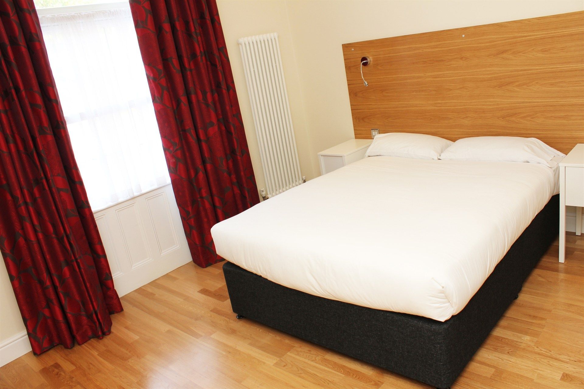 A hotel room with a bed and a window