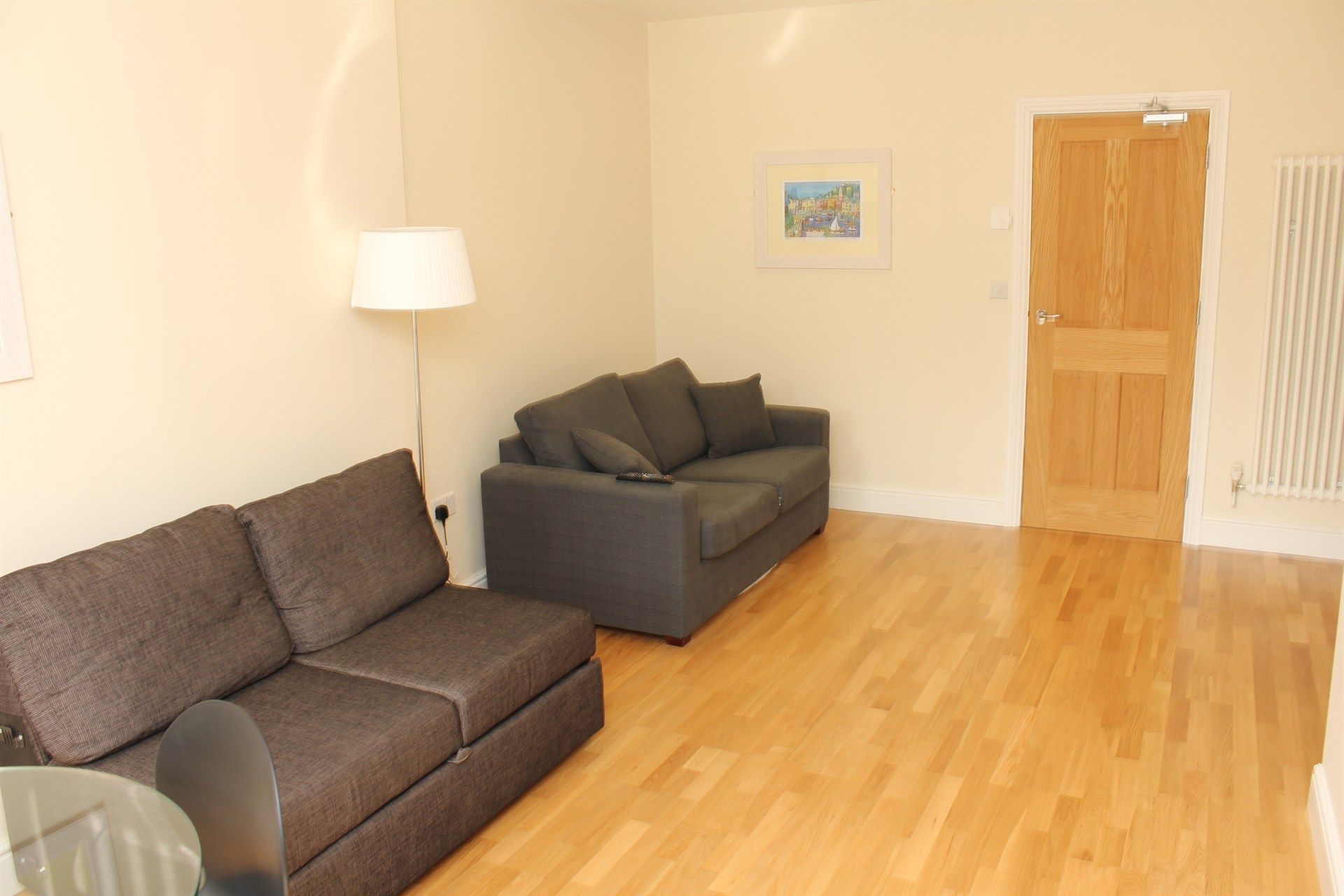 A living room with two couches and a lamp