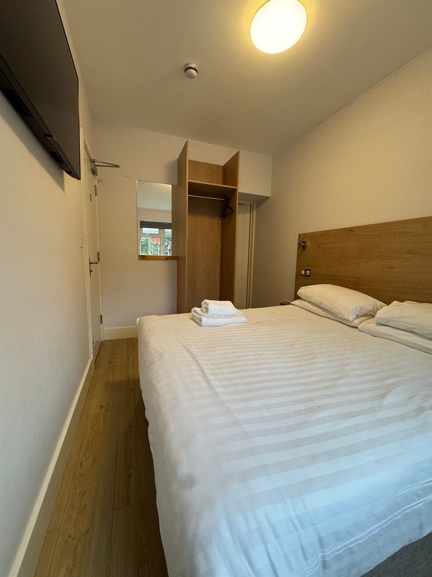 A hotel room with a king size bed and a flat screen tv.