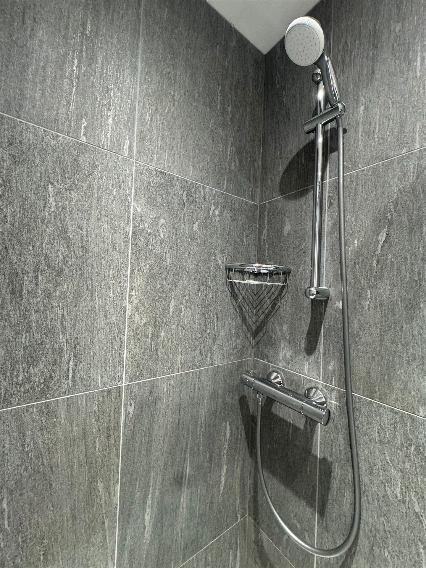 A close up of a shower head in a bathroom.