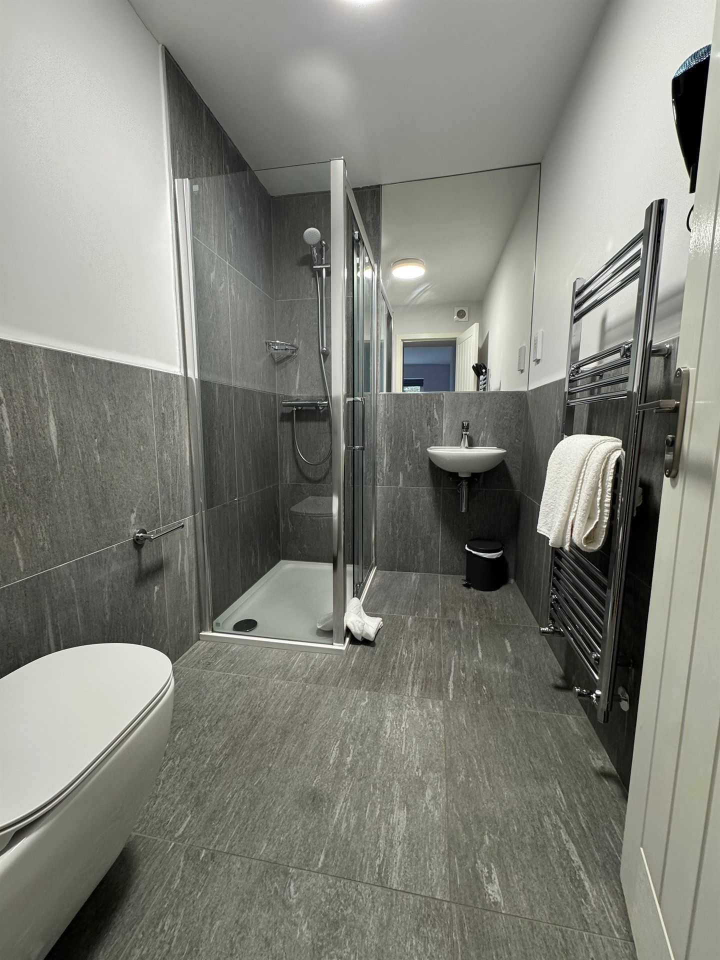 A bathroom with a toilet , sink , and shower.