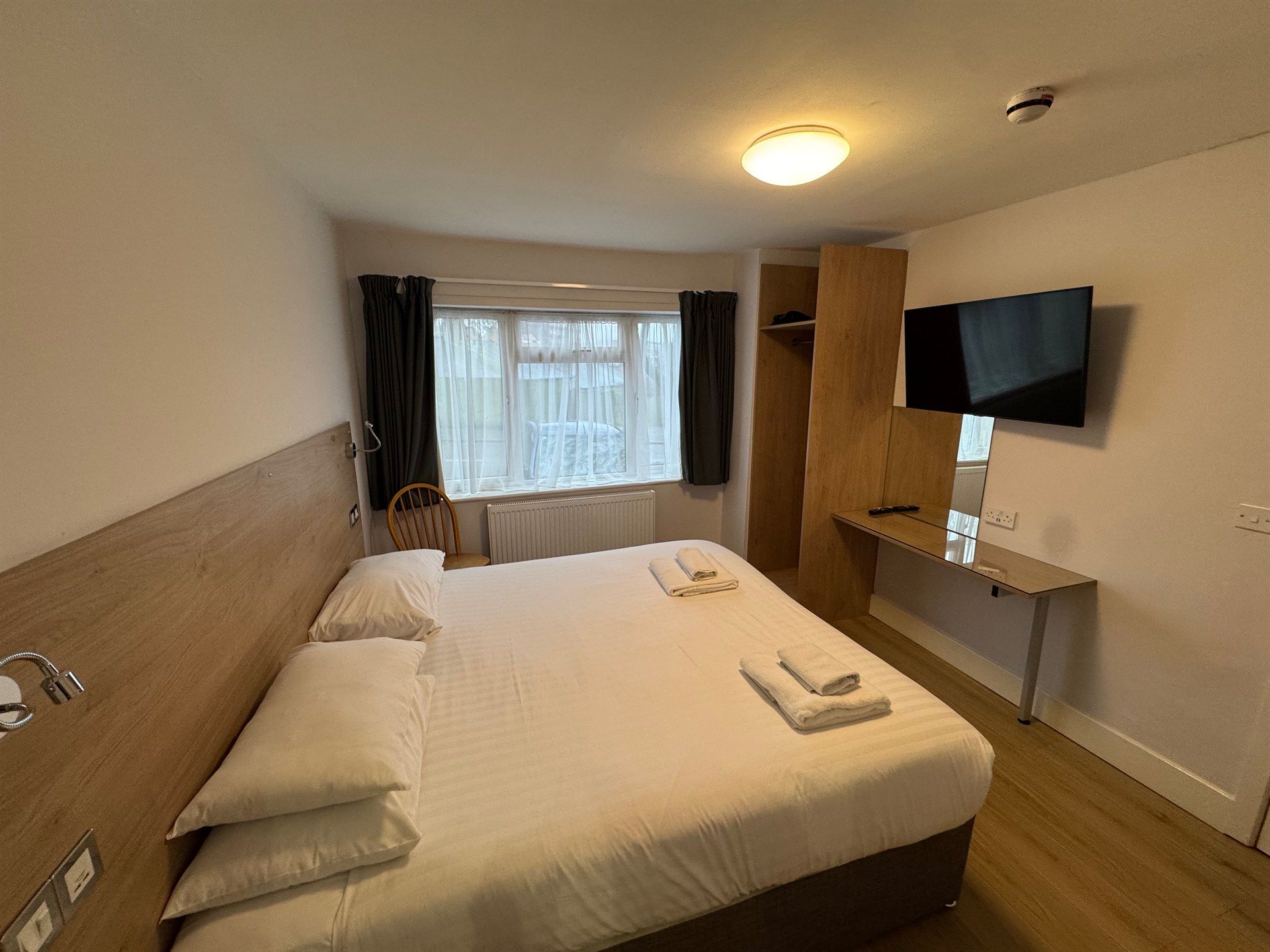 A hotel room with a king size bed and a flat screen tv.