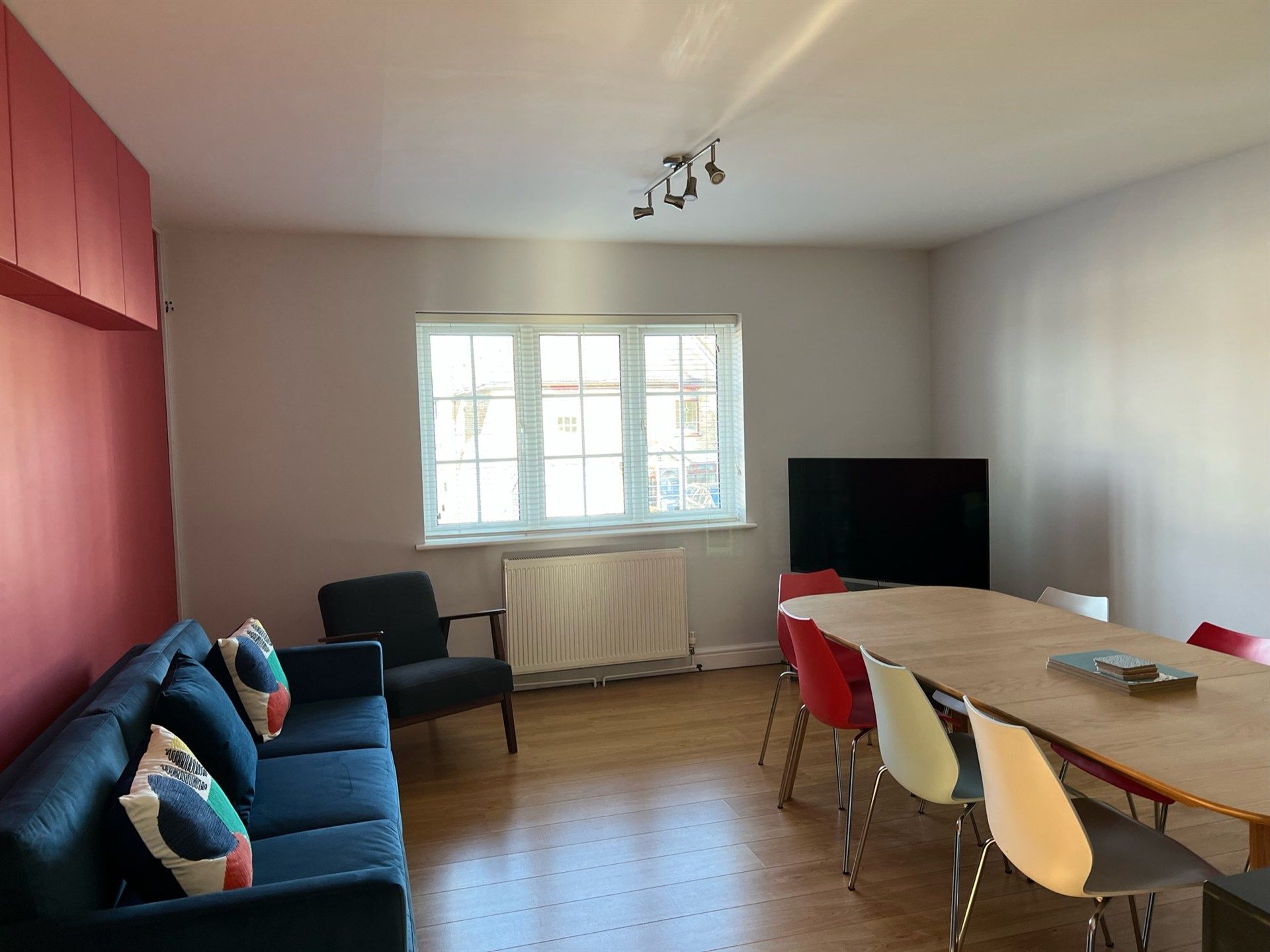 A living room with a couch , chairs , table and television.