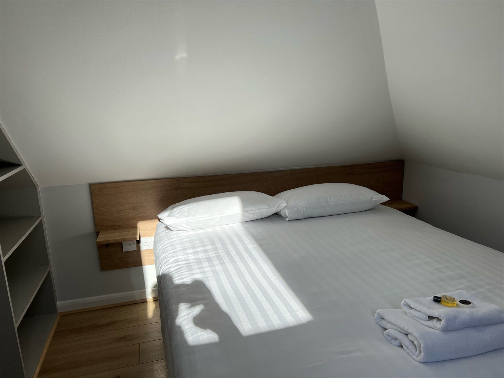 A bedroom with a bed and two towels on it.