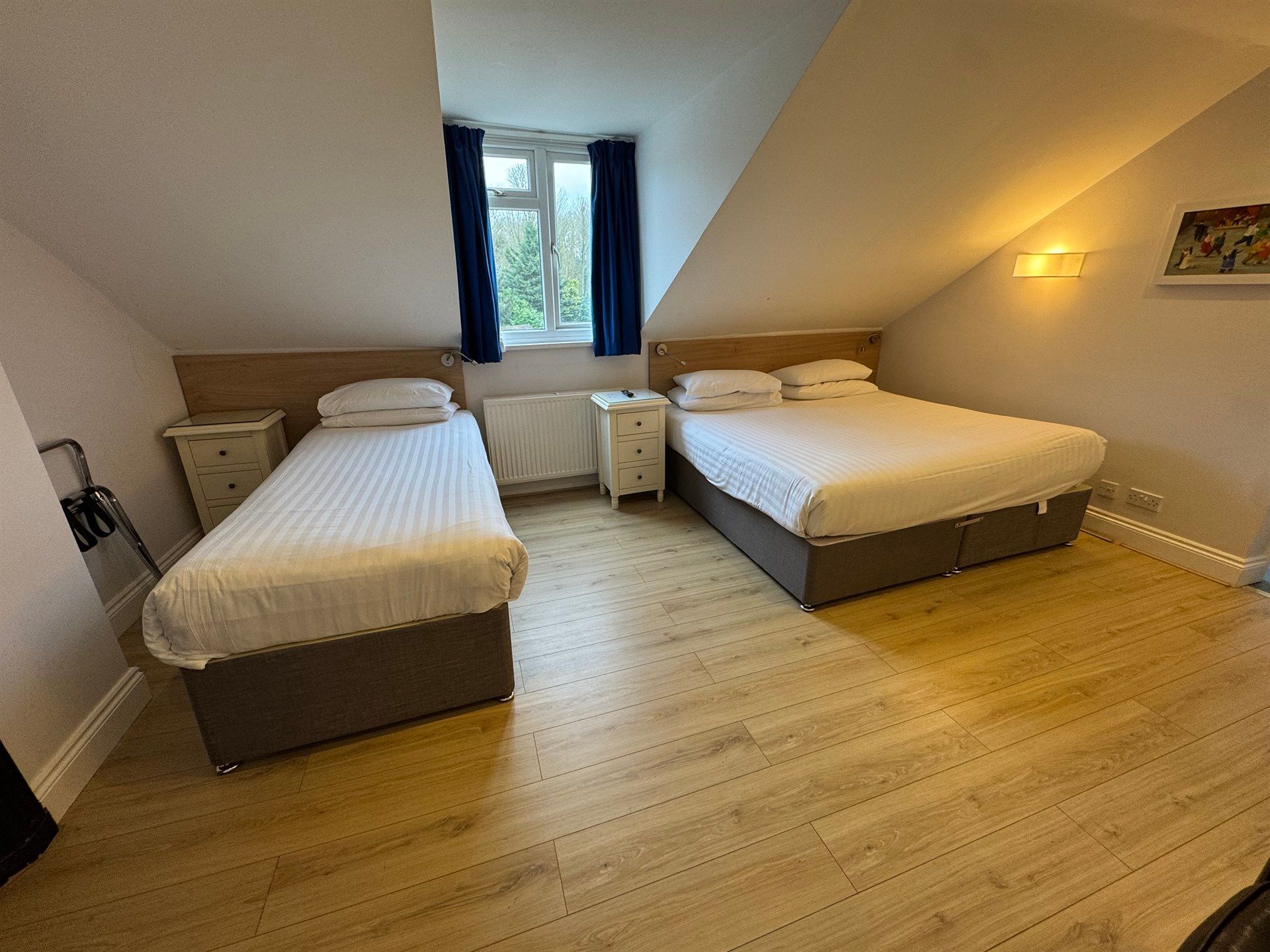 A bedroom with two beds and a window.