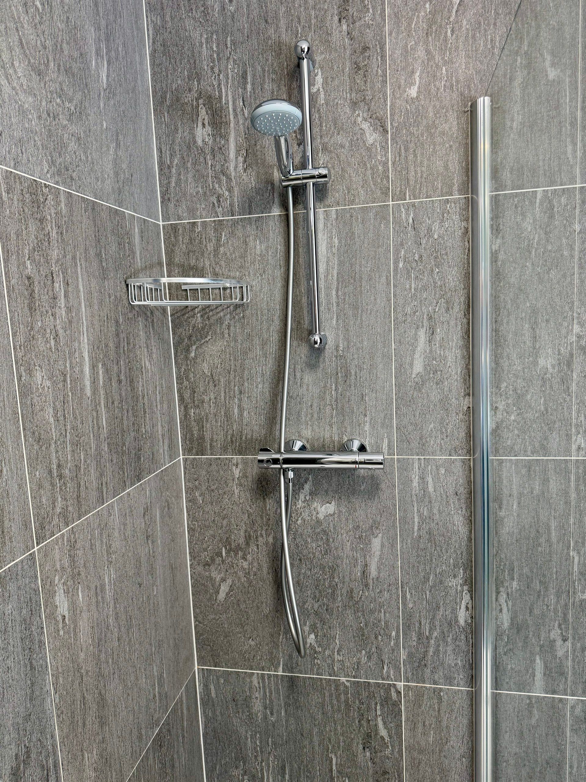 A close up of a shower head in a bathroom.