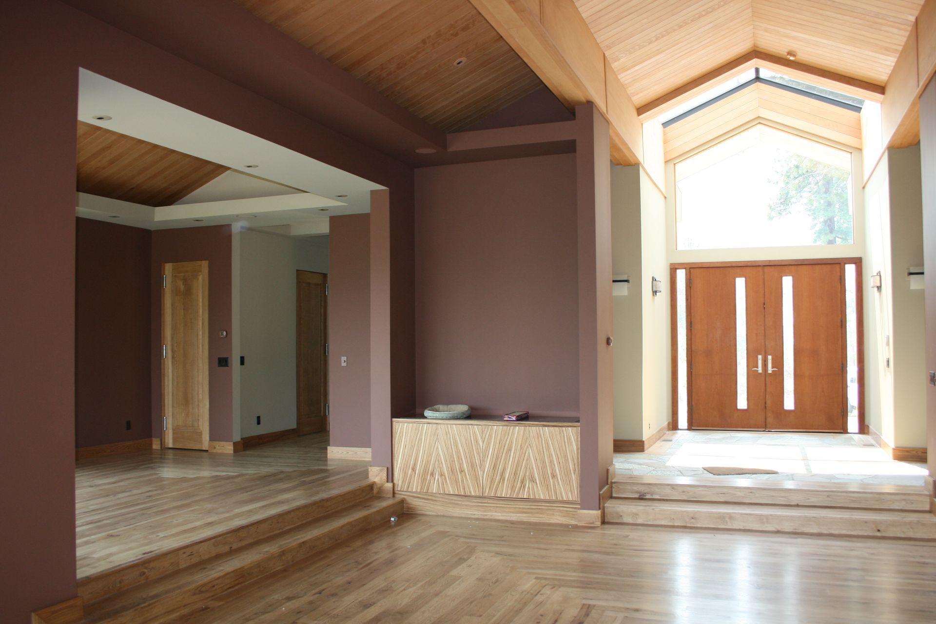A large empty room with purple walls and wooden floors
