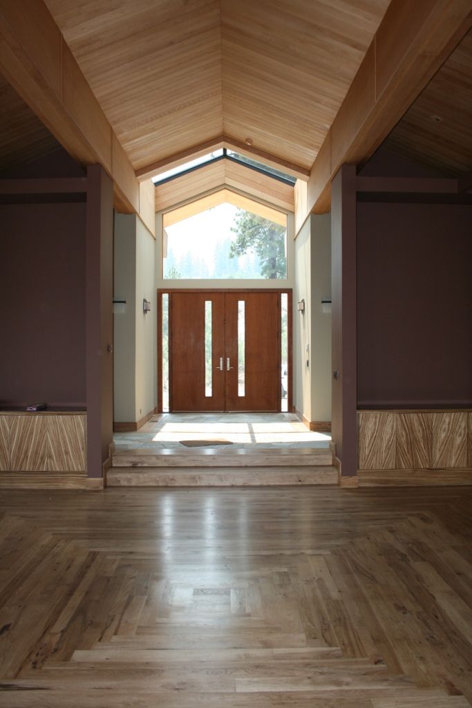 An empty room with a wooden floor and a wooden door