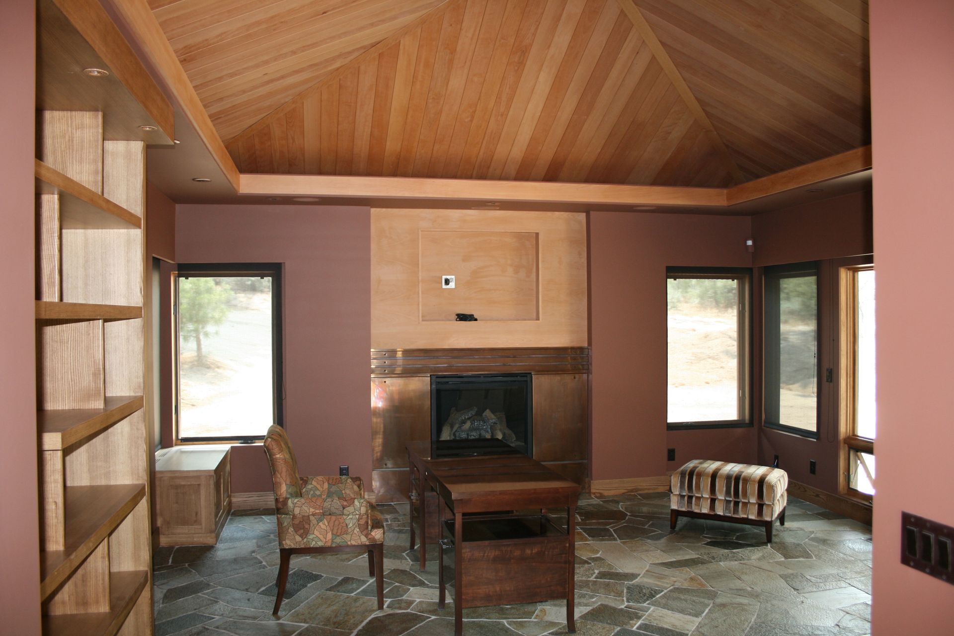 A living room with a fireplace and lots of windows