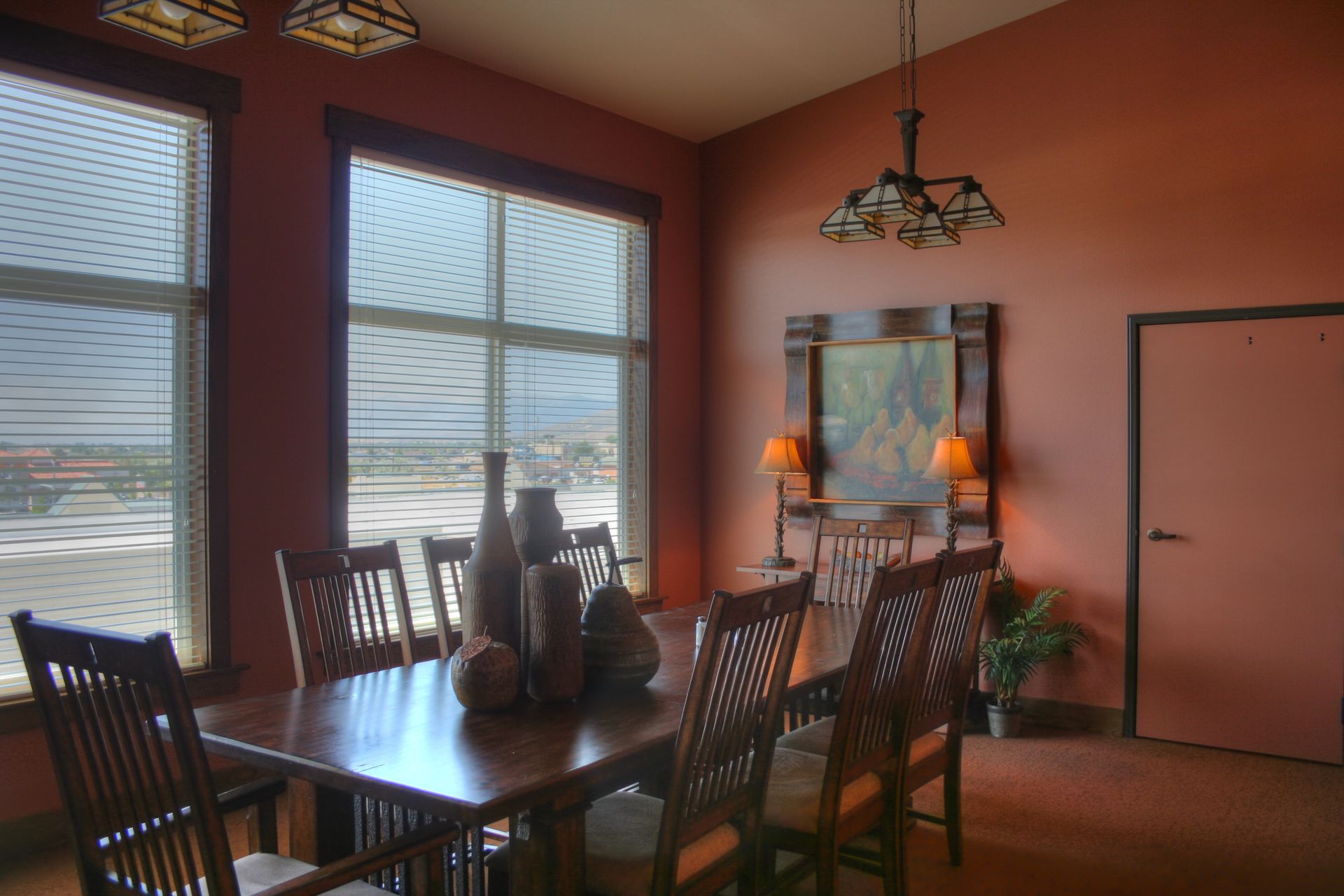 A dining room with a table and chairs and red walls