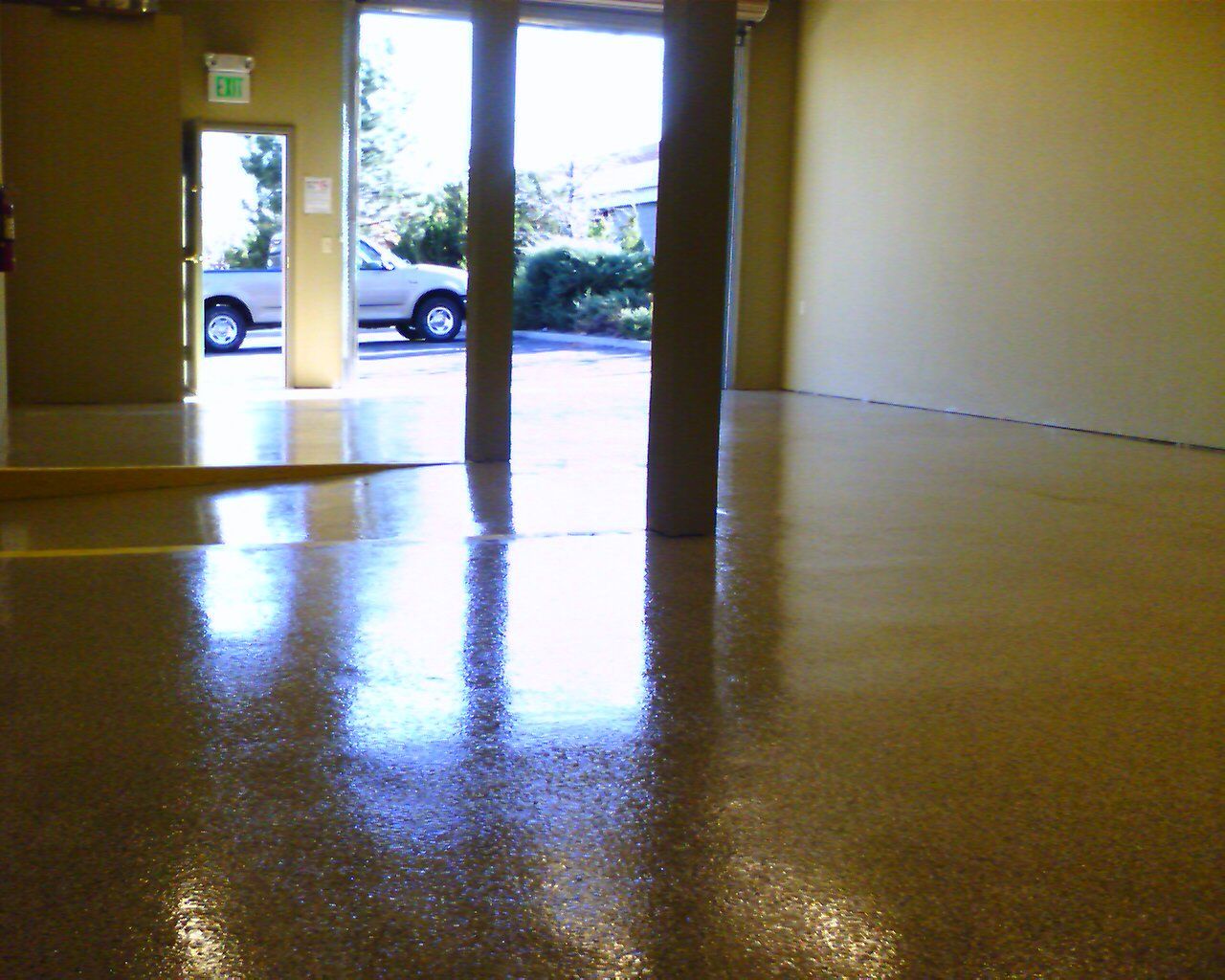 An empty room with a car parked in the background