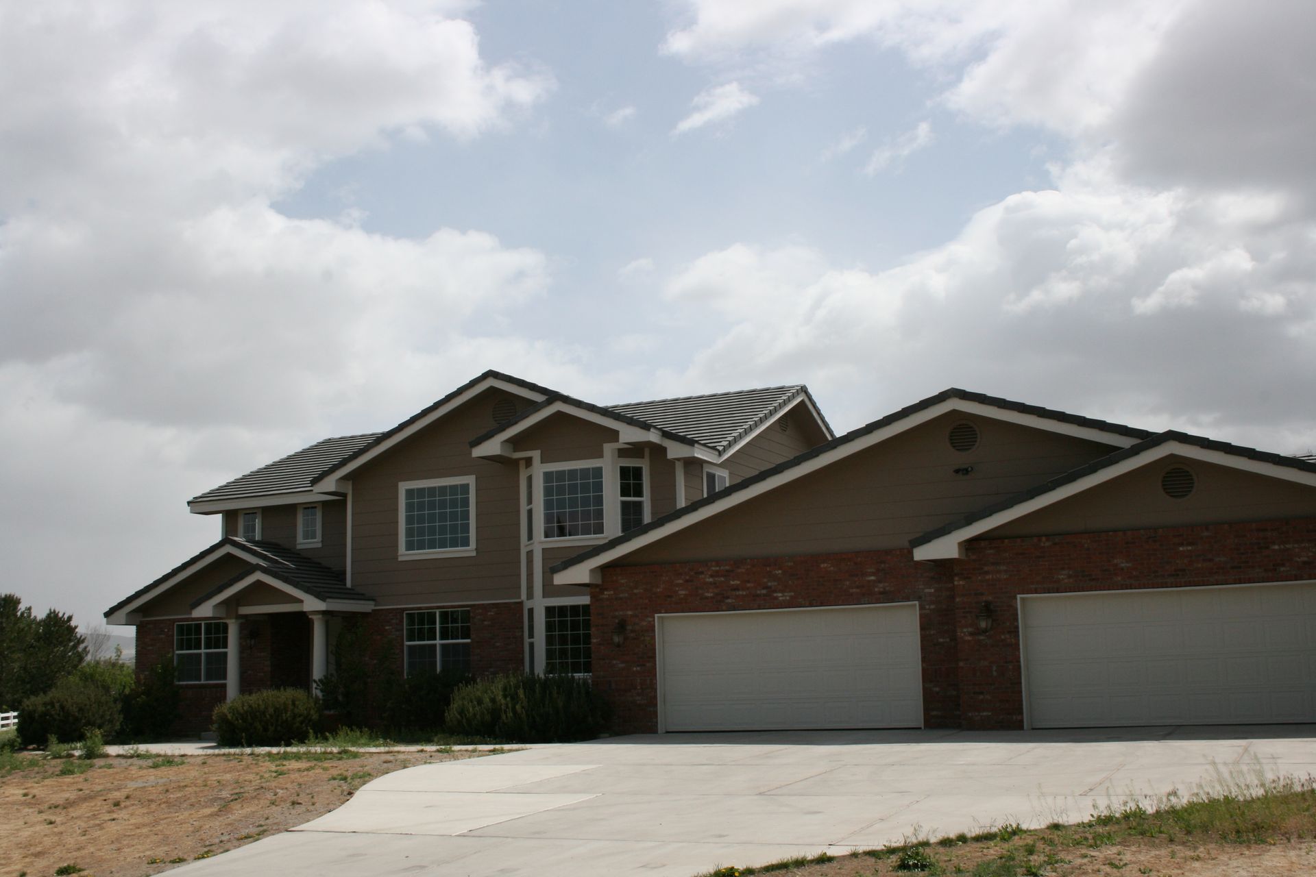 A large house with three garage doors and a driveway