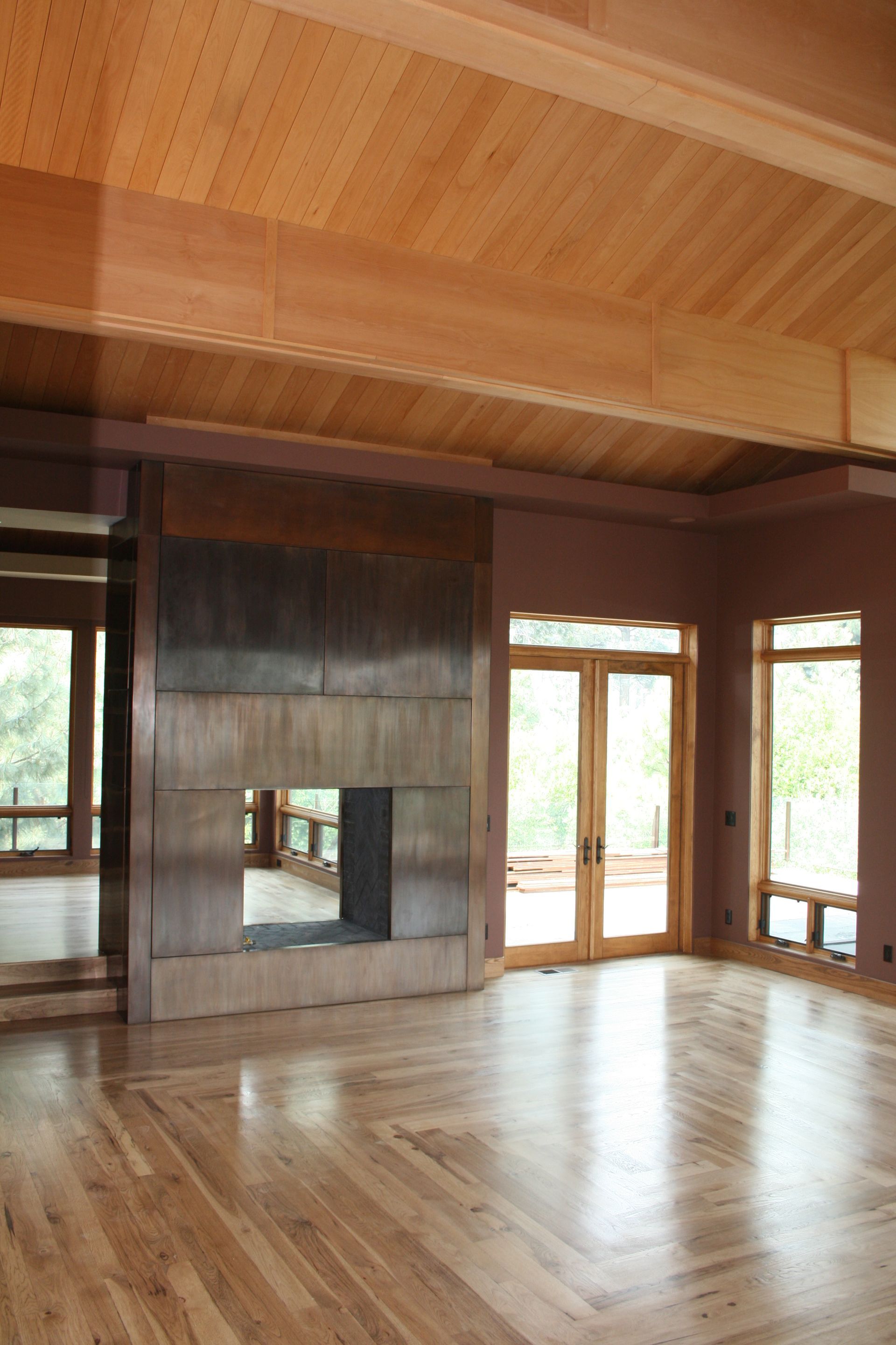 A large empty room with hardwood floors and a fireplace