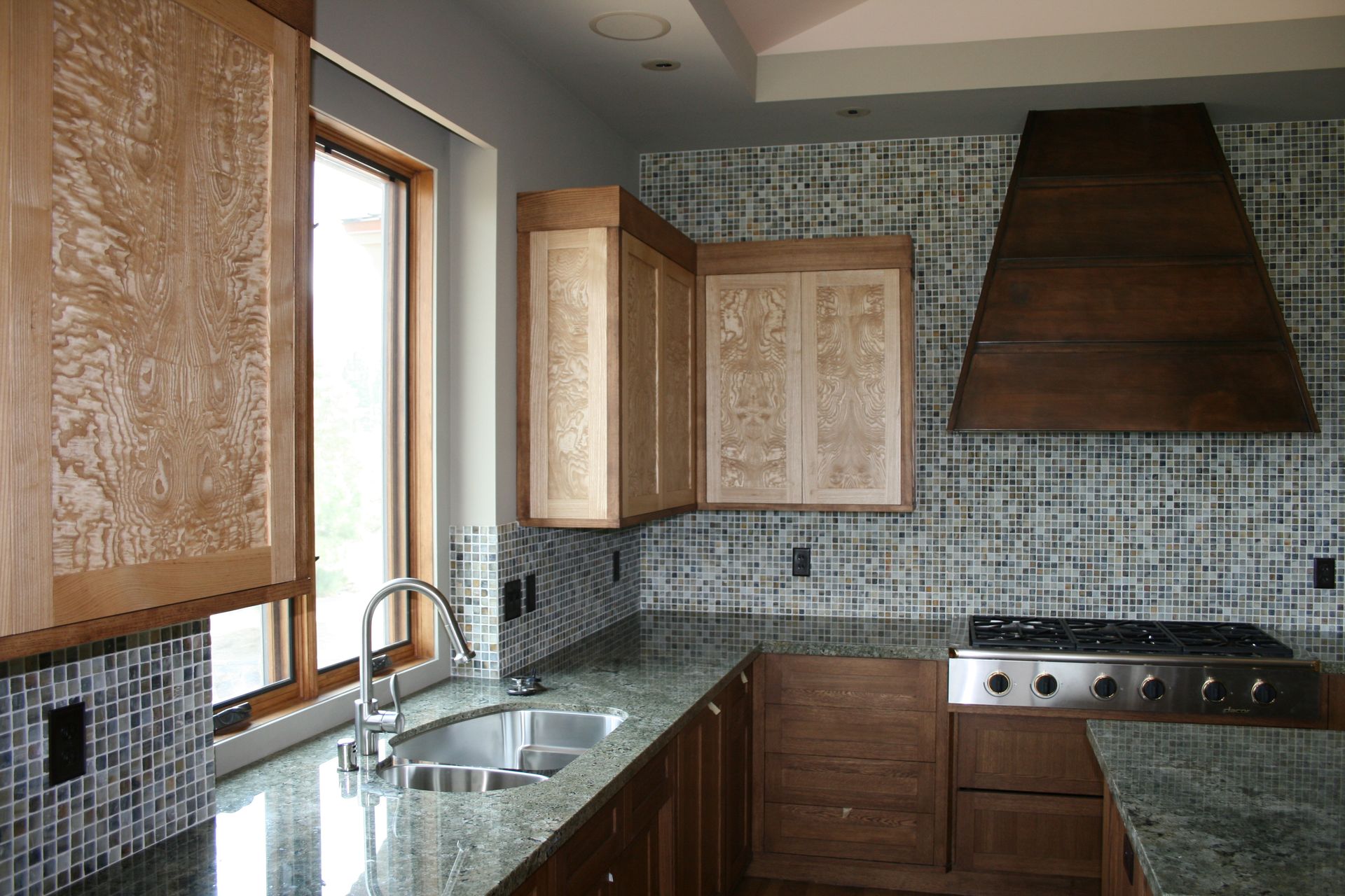 A kitchen with a stove a sink and a window