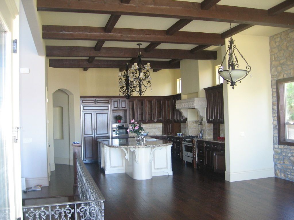 A kitchen with a large island and a chandelier hanging from the ceiling