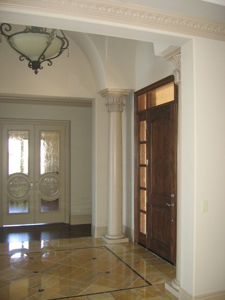 A hallway with columns and doors in a house