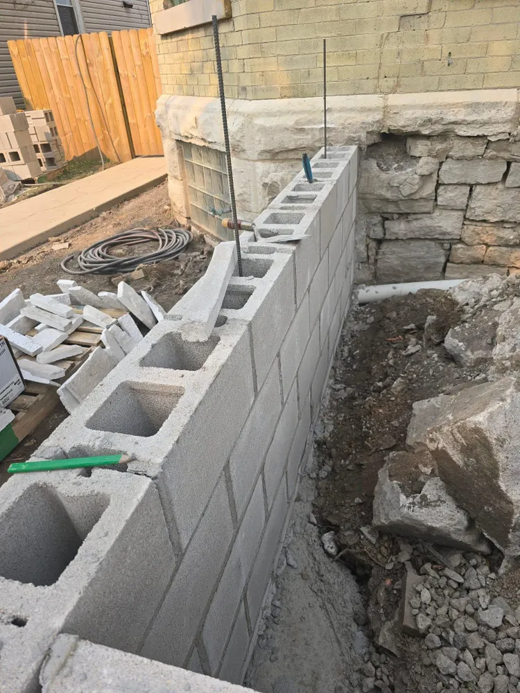 Brick house with a large window and gable roof against a blue sky.