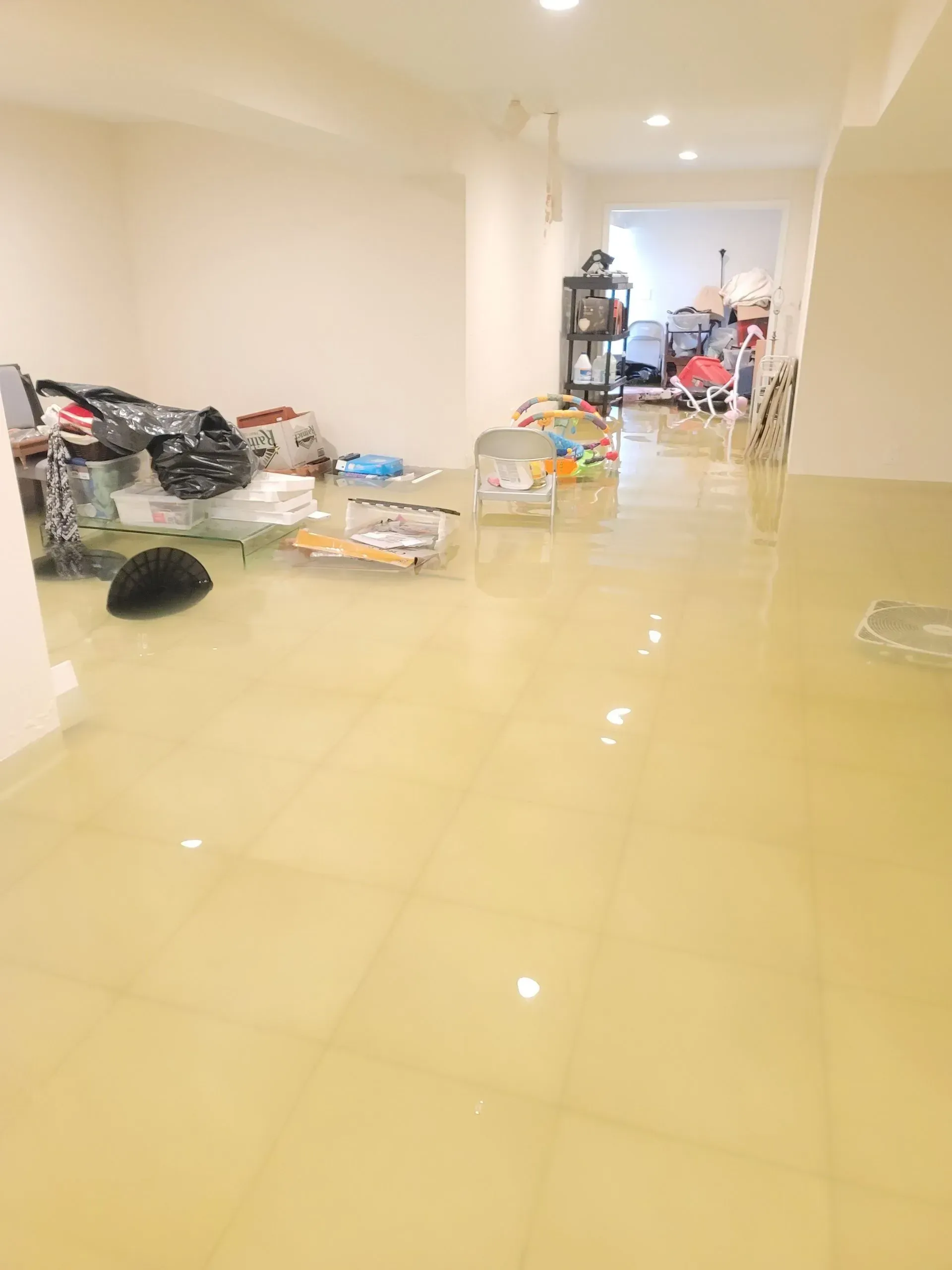 A flooded basement with a lot of toys on the floor.