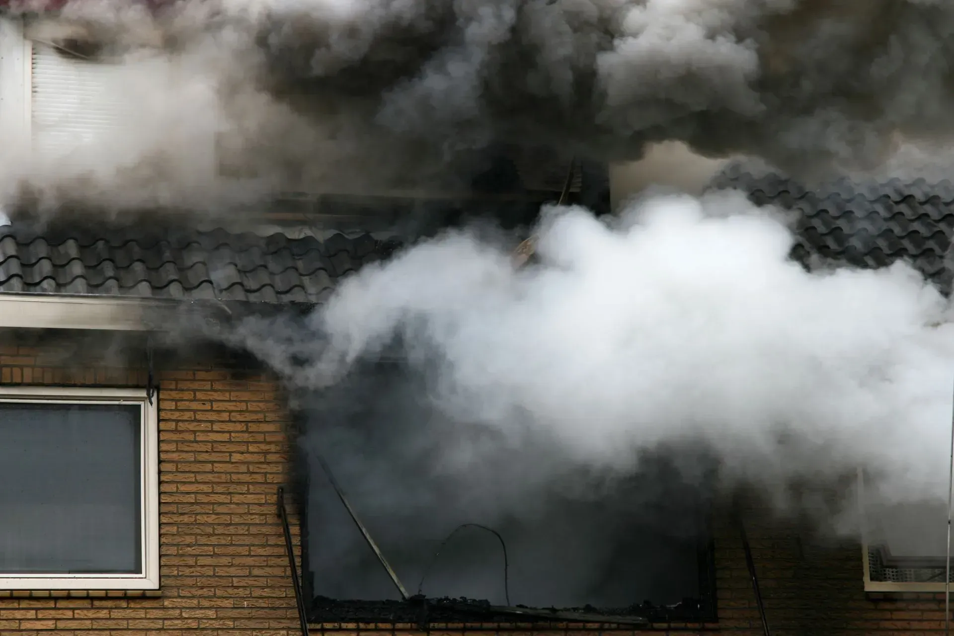 Smoke is coming out of the roof of a building.