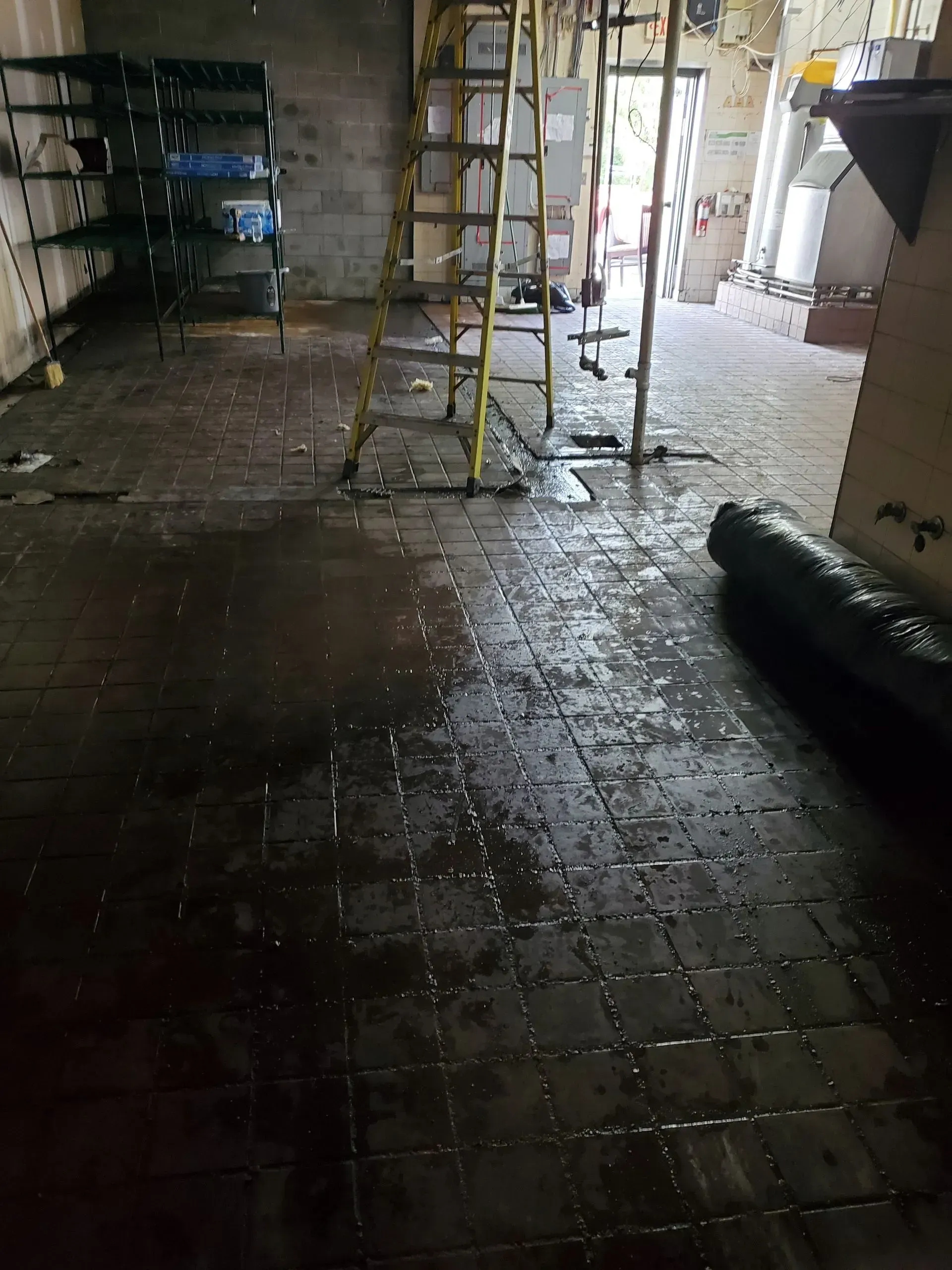 A dirty room with a ladder on the floor.