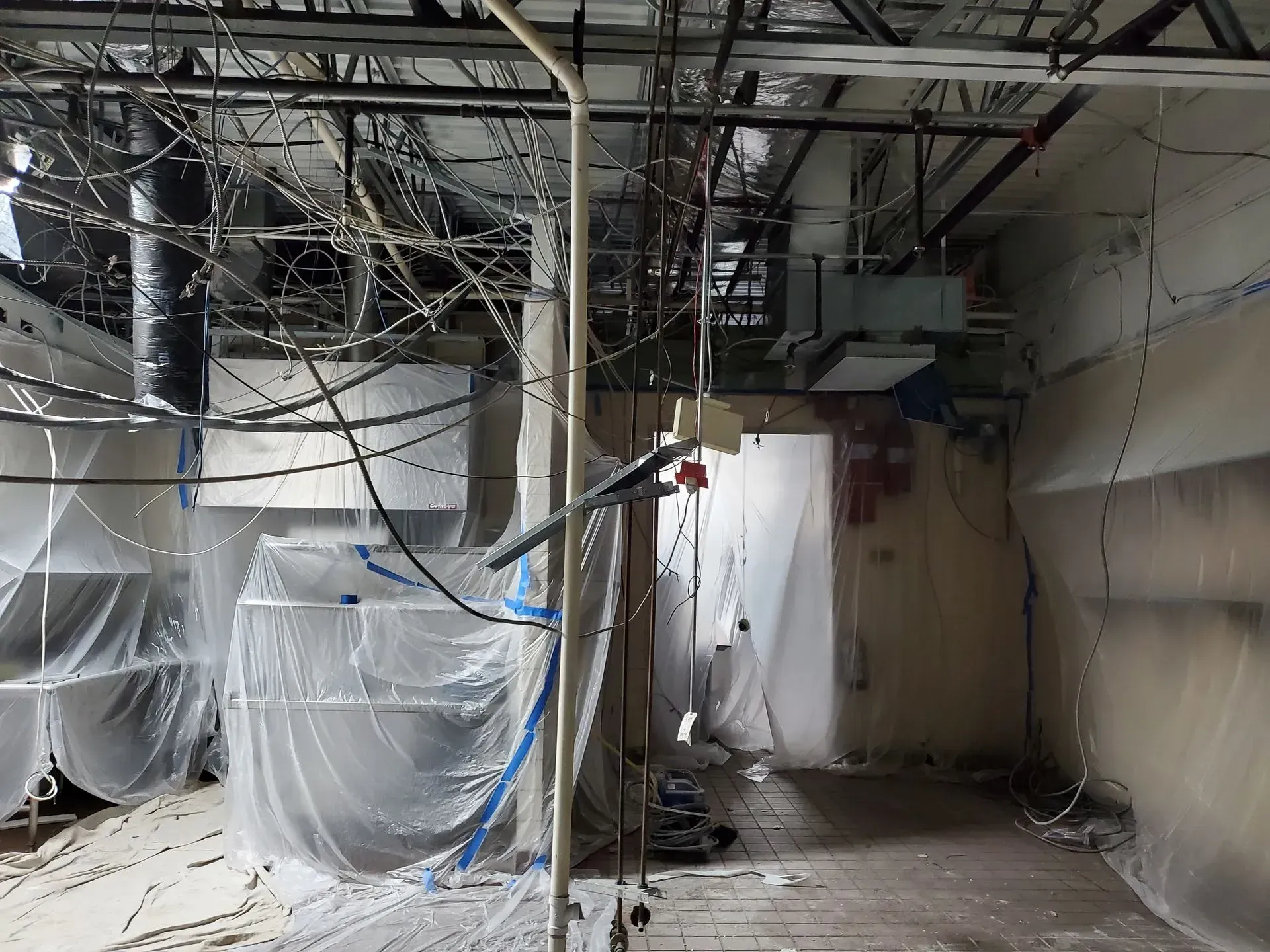 An empty room with a lot of wires hanging from the ceiling.