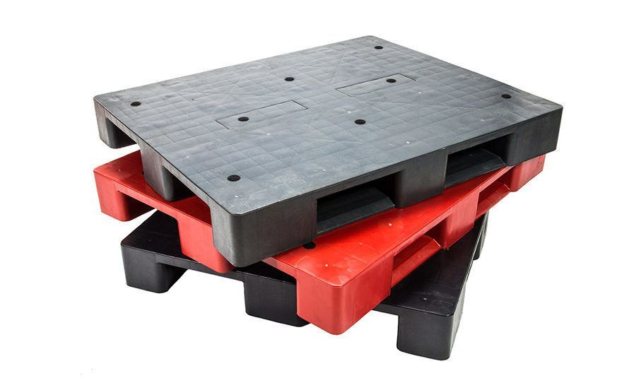 A stack of three industrial plastic pallets, featuring two black pallets on the top and bottom with a red one in the middle.