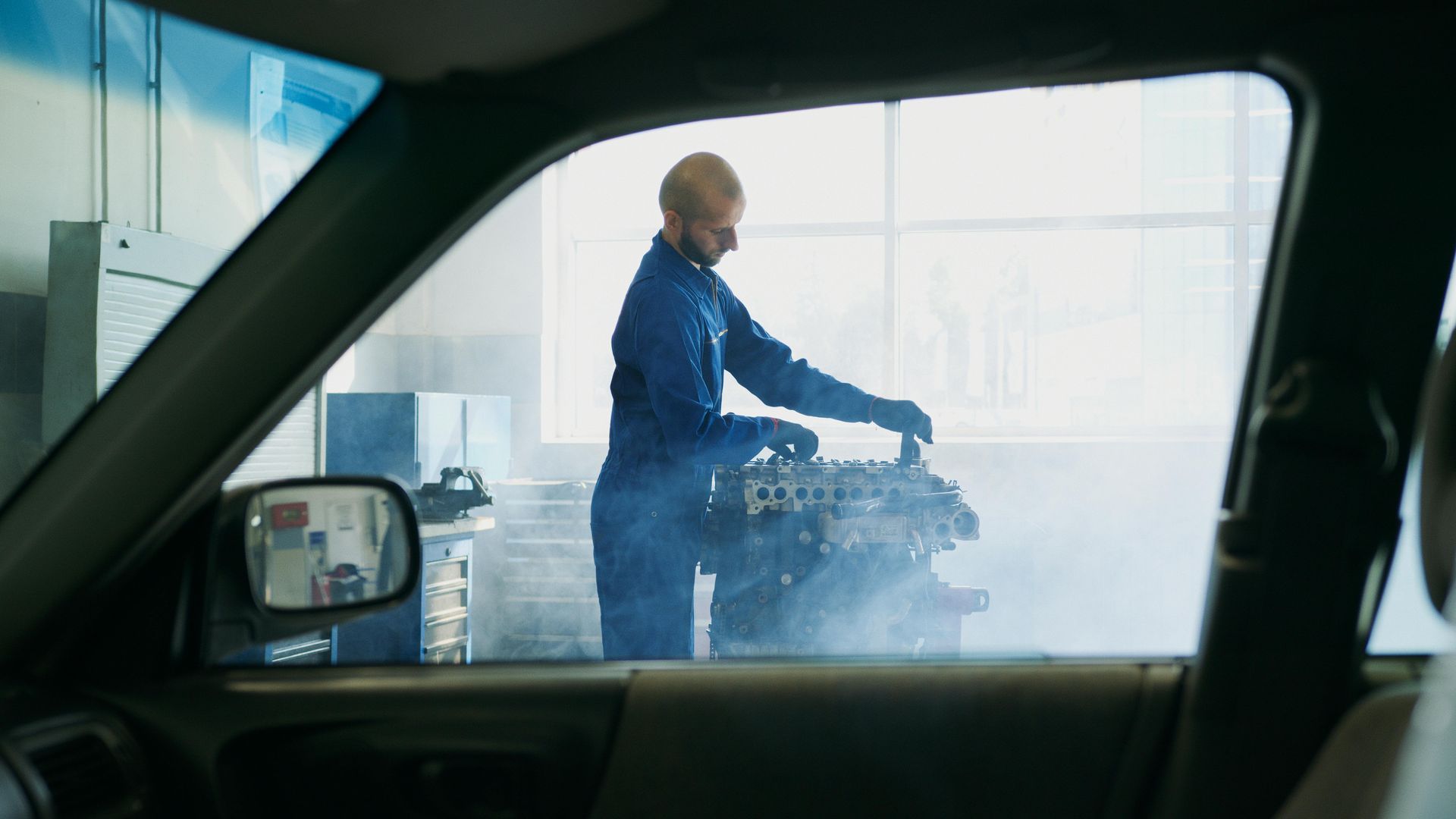 Mechanic working on a car engine inside aKumeu Car Services  garage