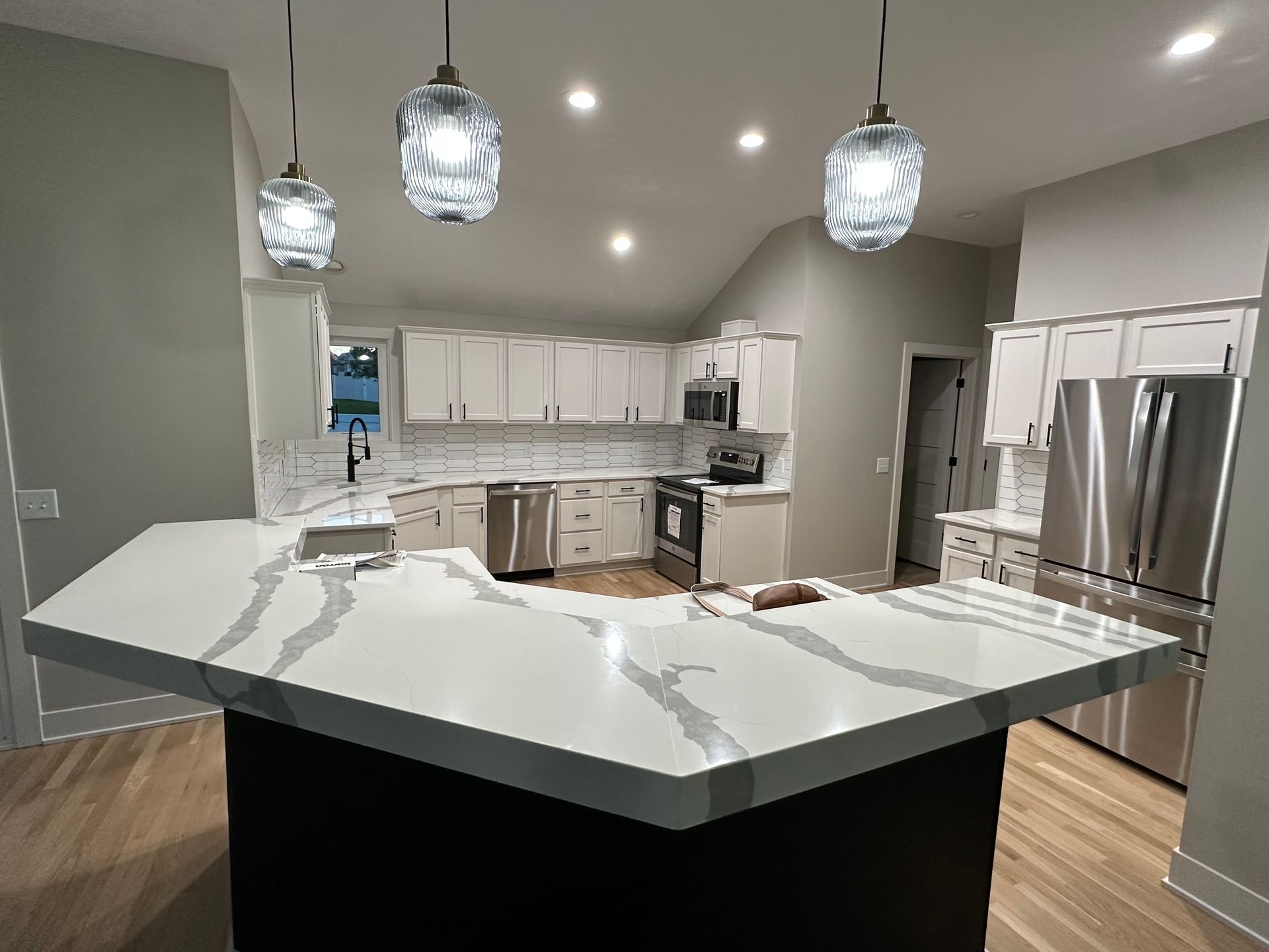 A kitchen with a large island and stainless steel appliances