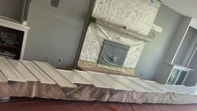 A living room with a fireplace and a mattress on the floor.