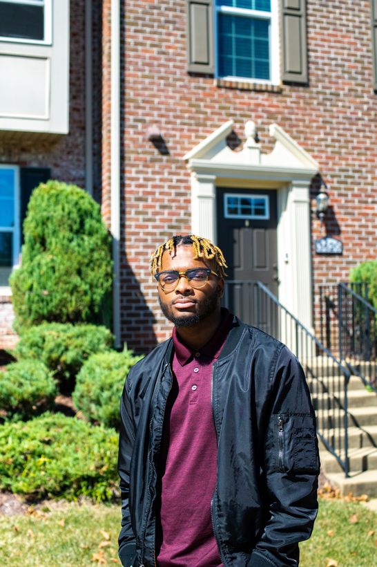 A man is standing in front of a townhomes.