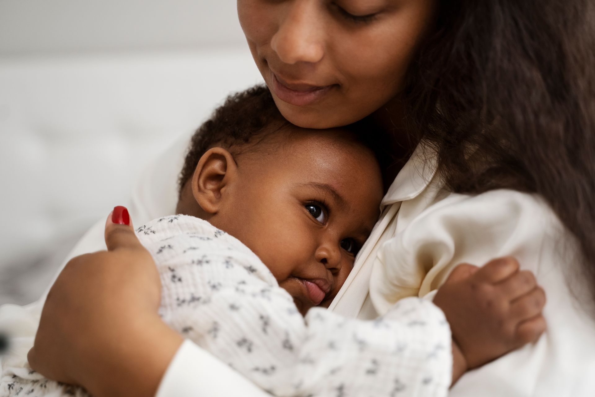 A first-time parent embraces their newborn, empowered by the midwifery model of care.
