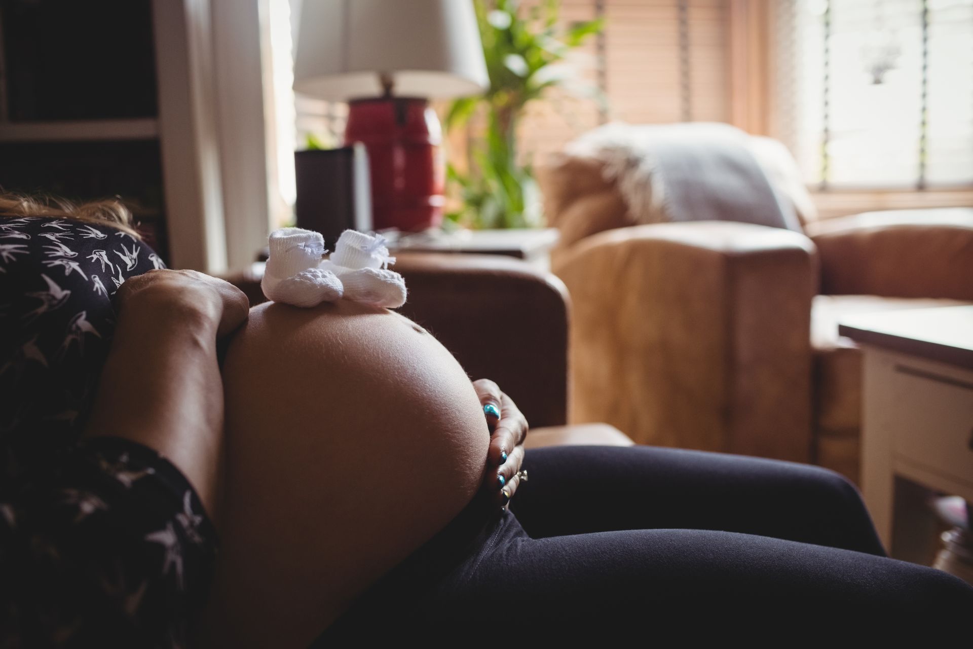 A pregnant person gently cradles their belly, longing for compassionate and holistic pregnancy care.