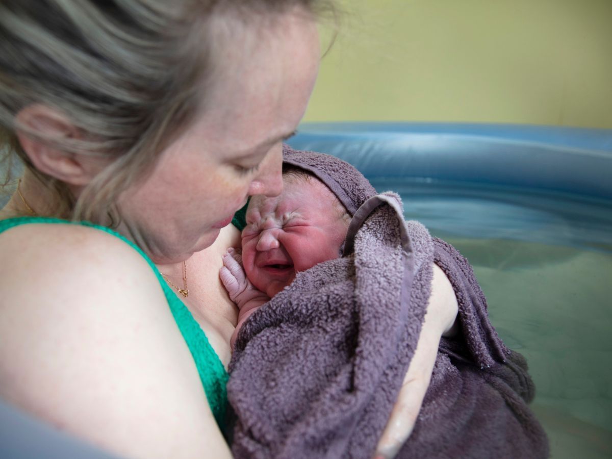 Birthing person and baby in birthing pool