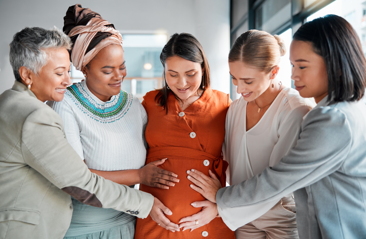 A pregnant person receiving support from friends and family 
