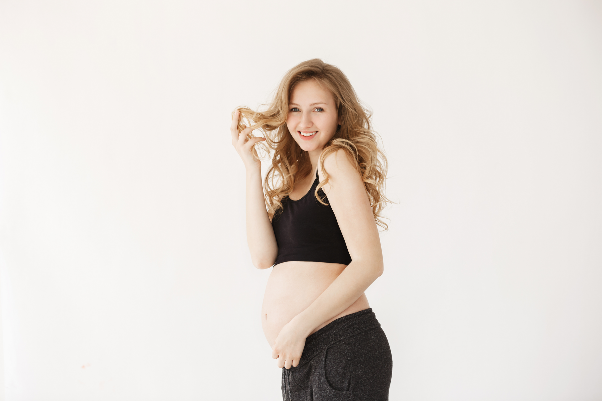 A pregnant person happily smiling after her midwife prenatal care appointment