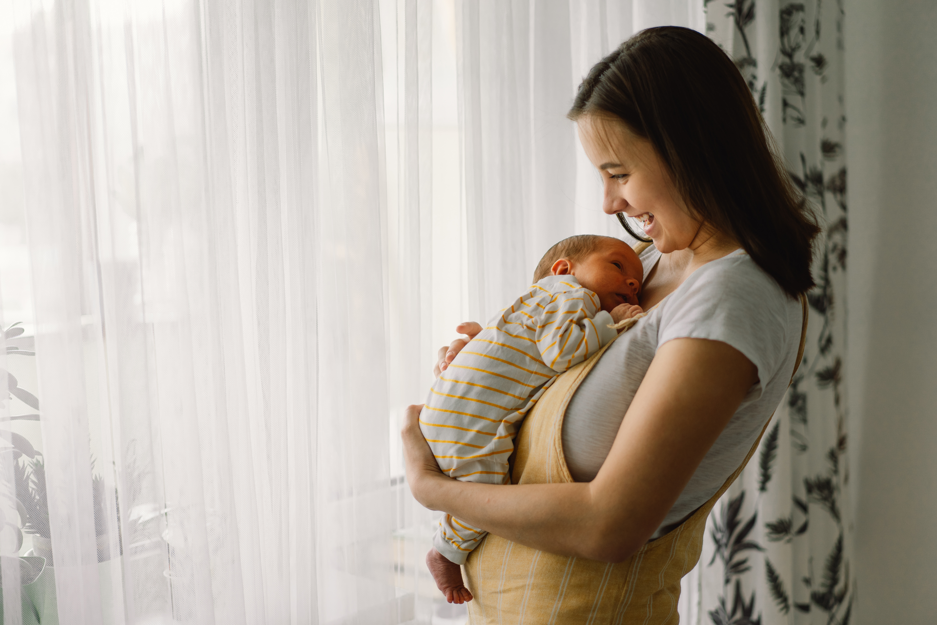 A first-time mom carries her baby, knowing they have all the newborn essentials.