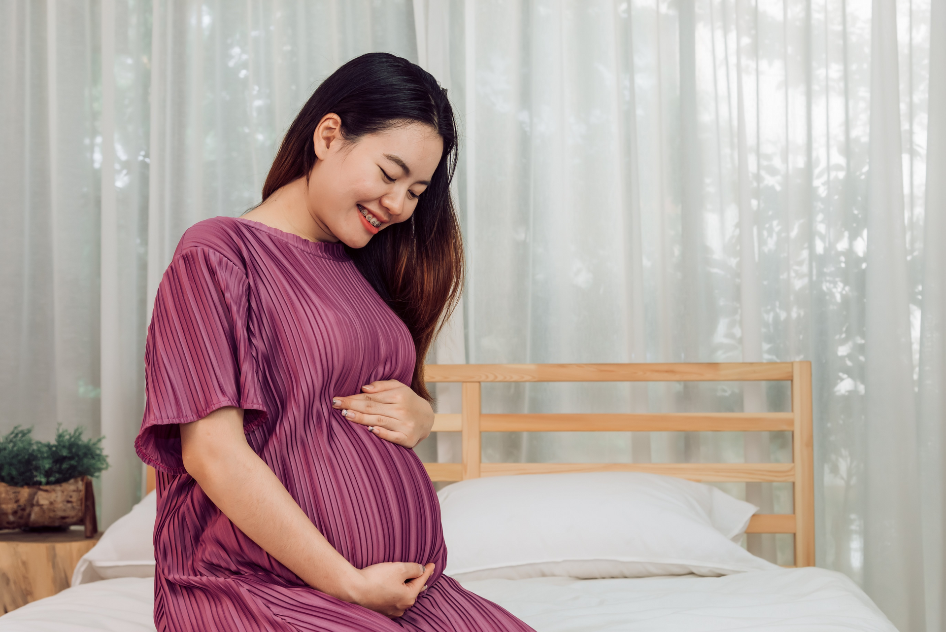 A pregnant client comfortably waits for the doctor during a check-up at a woman care center.