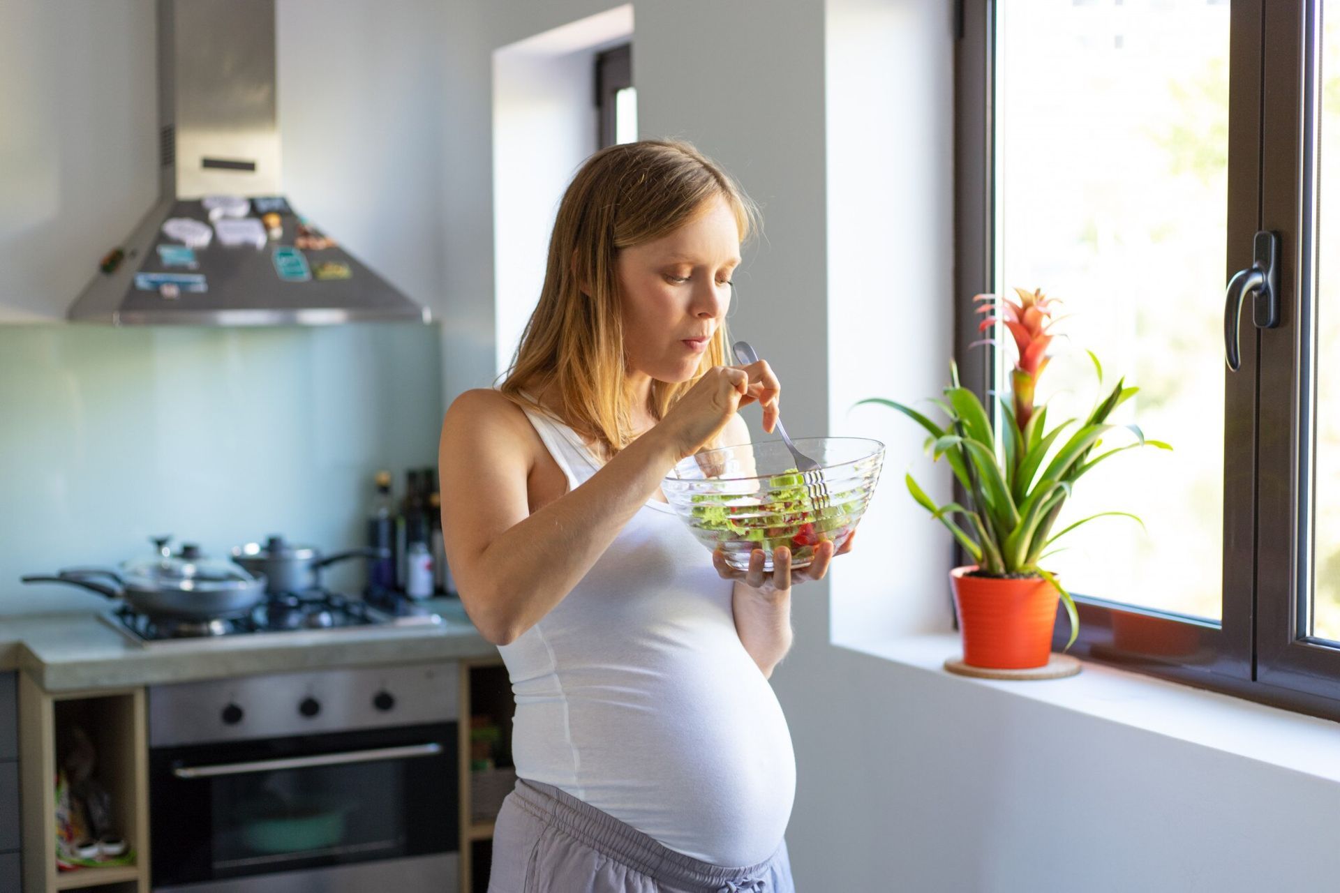 A pregnant woman enjoys a salad, carefully following a nutritious diet for pregnant women.
