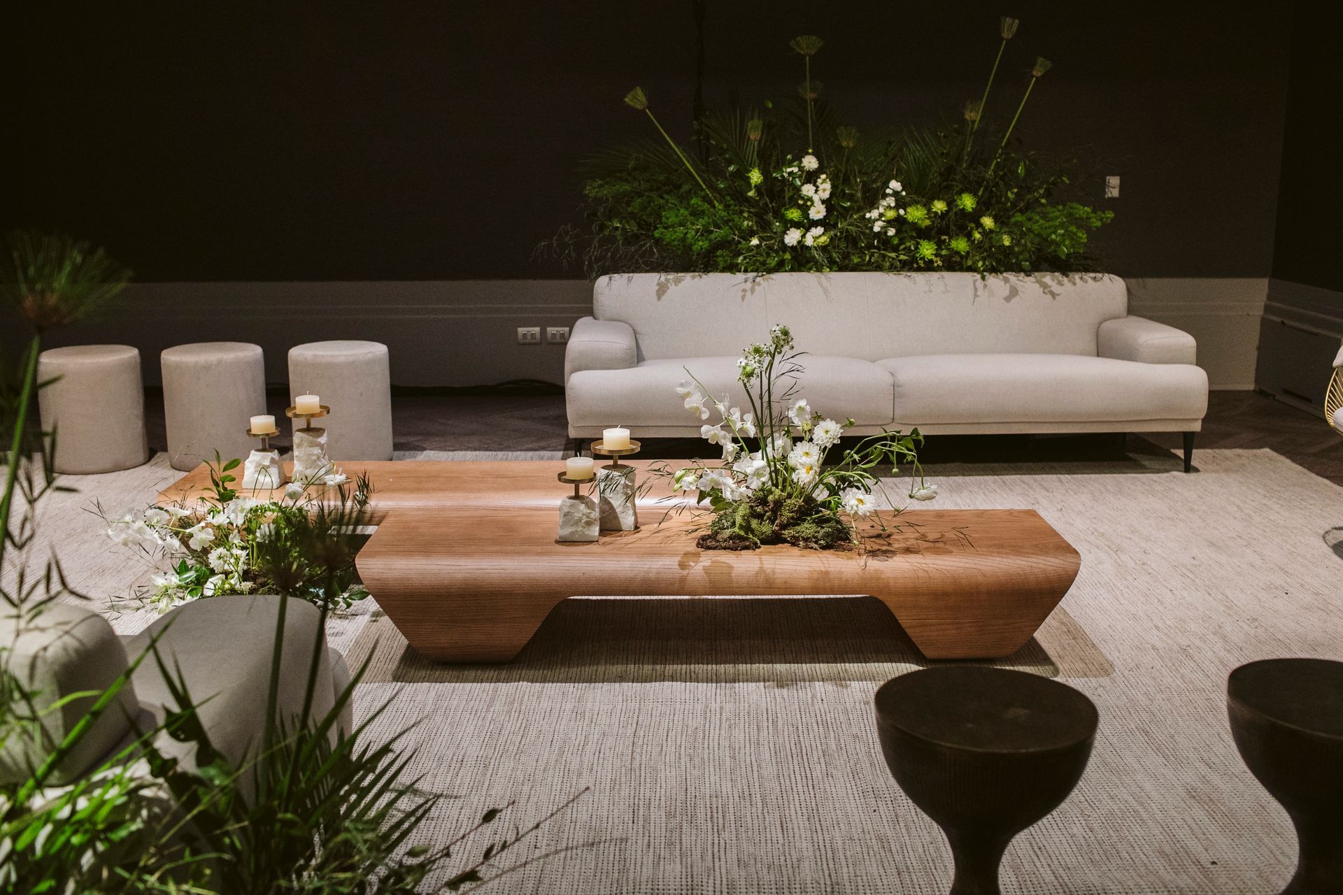 Uma sala de estar com um sofá, mesa de centro e bancos.