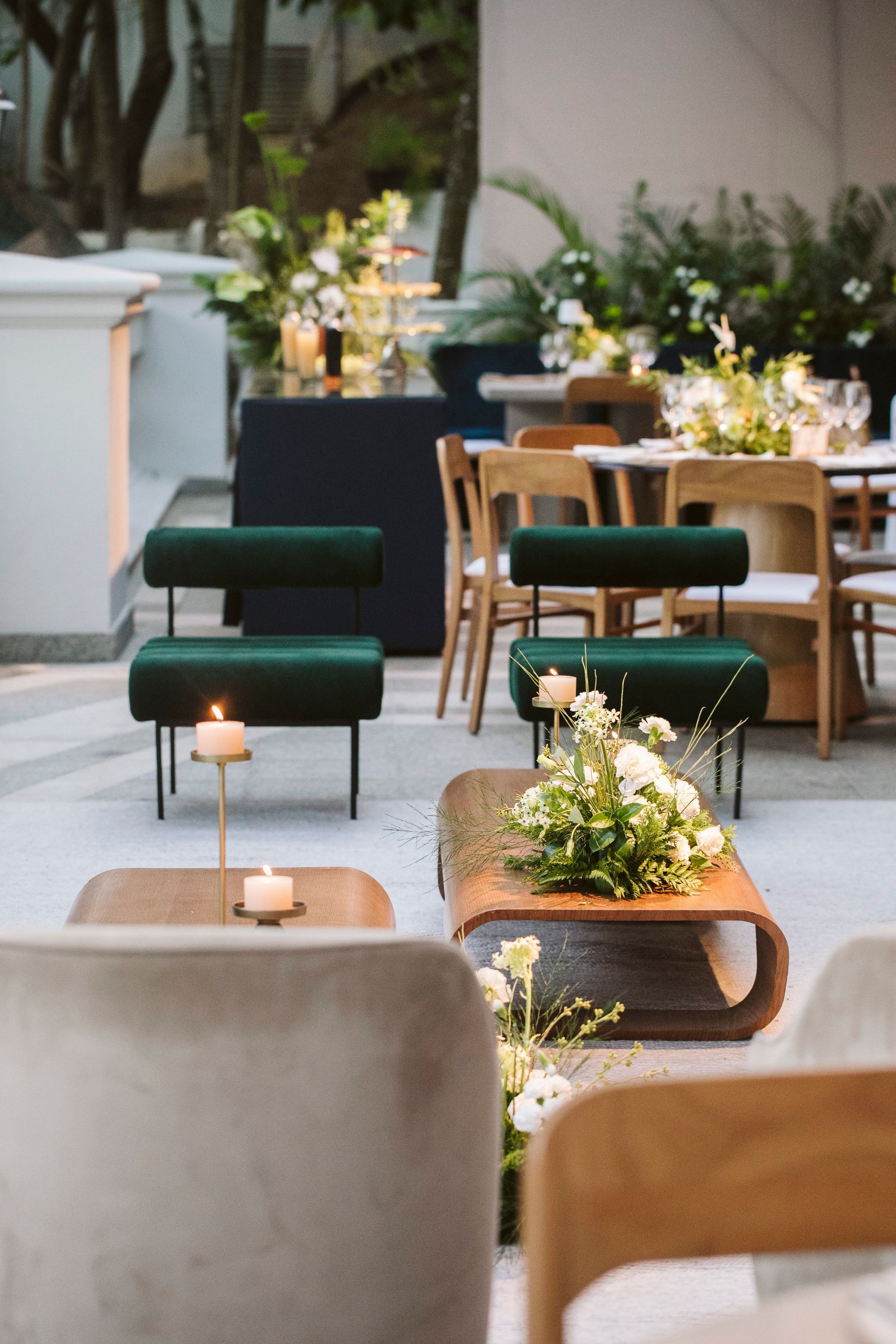 Uma fileira de cadeiras e mesas com velas em uma sala.