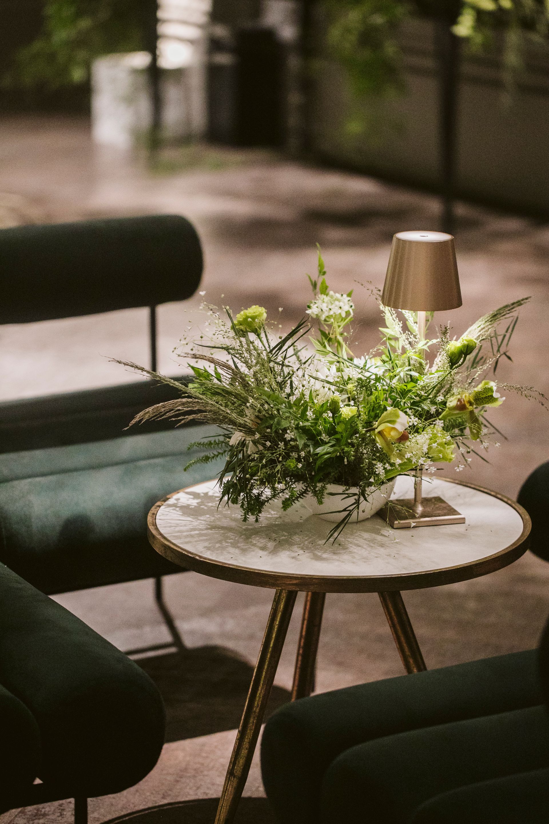 Uma mesa com um vaso de flores e um abajur sobre ela.