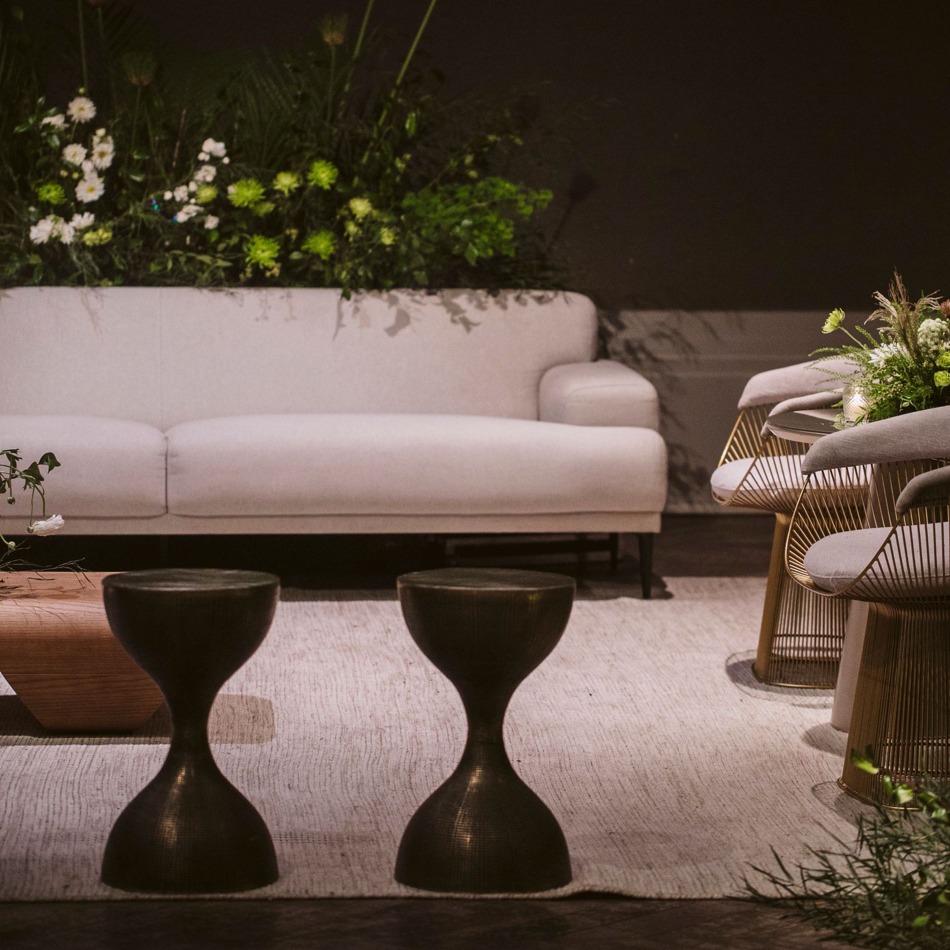 Uma sala de estar com um sofá branco e dois bancos pretos