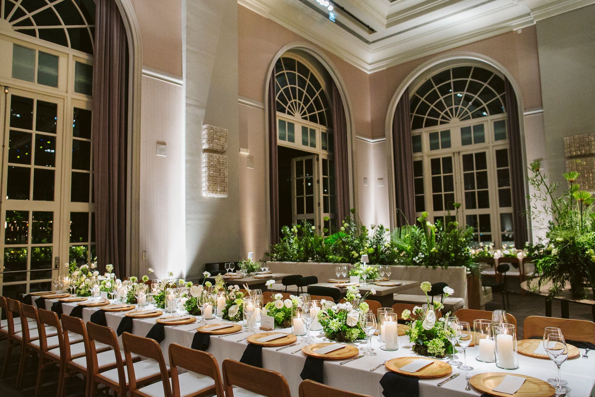 Uma grande sala com mesas e cadeiras preparadas para uma recepção de casamento.