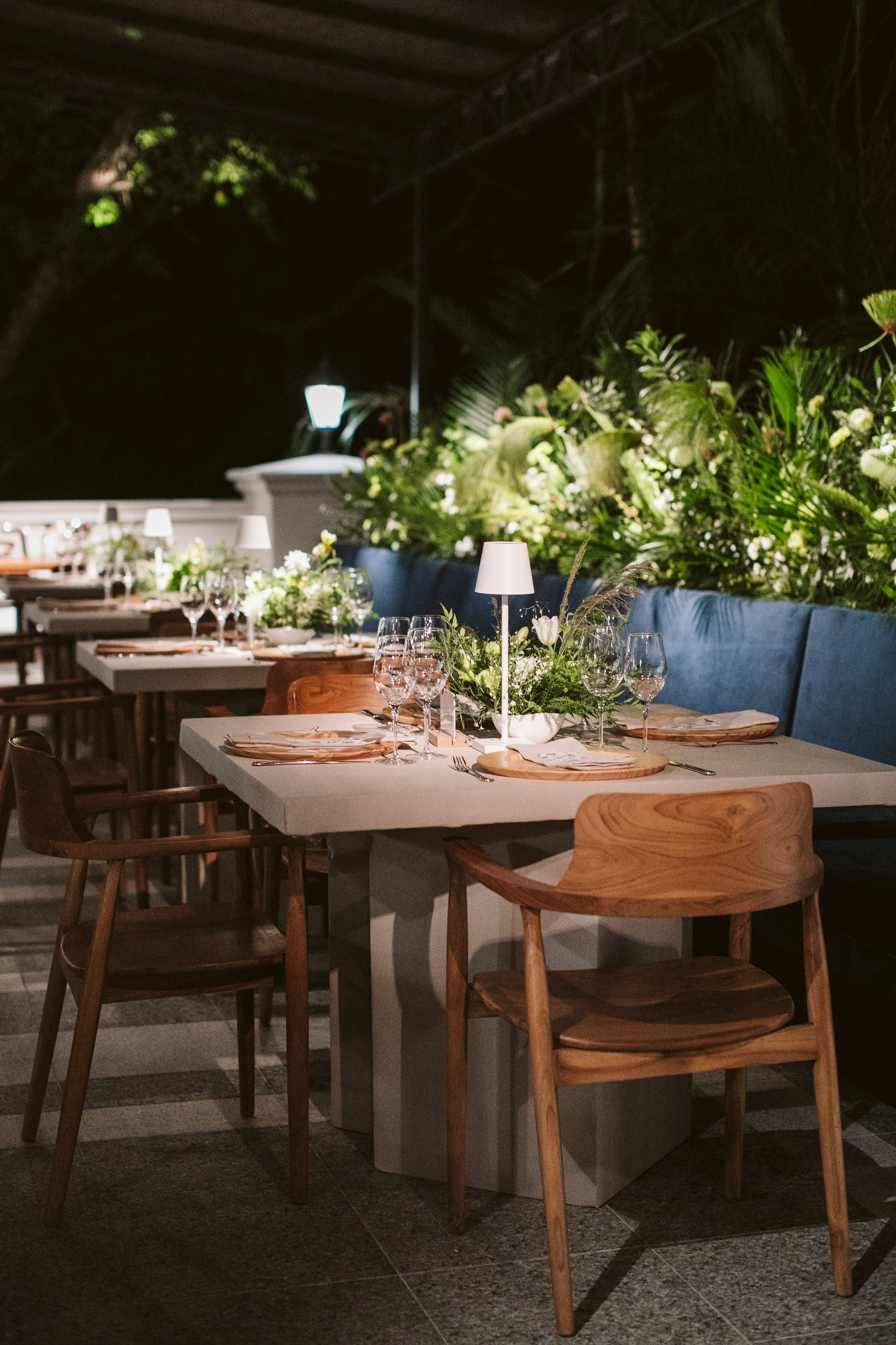 Uma fileira de mesas e cadeiras em um restaurante à noite.